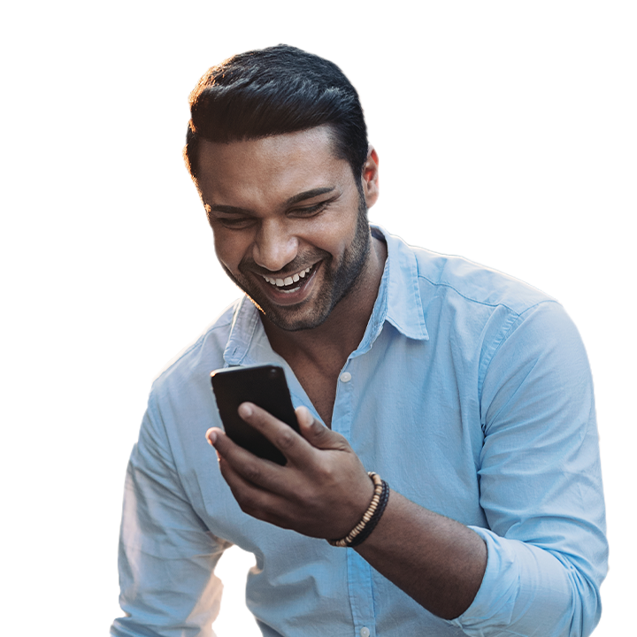 man smiling while staring at his phone screen